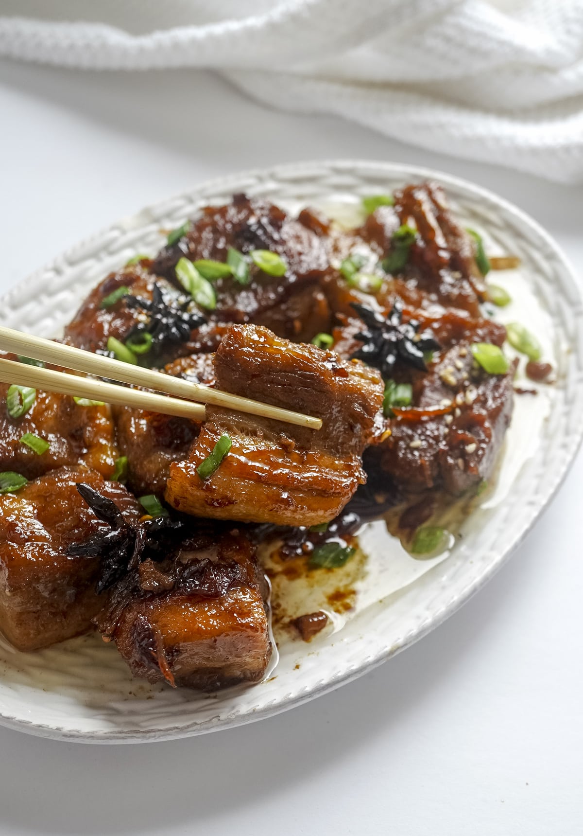 Picture of braised pork belly in a chop sticks