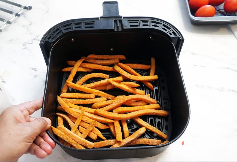 Image of frozen potato fries in the air fryer basket